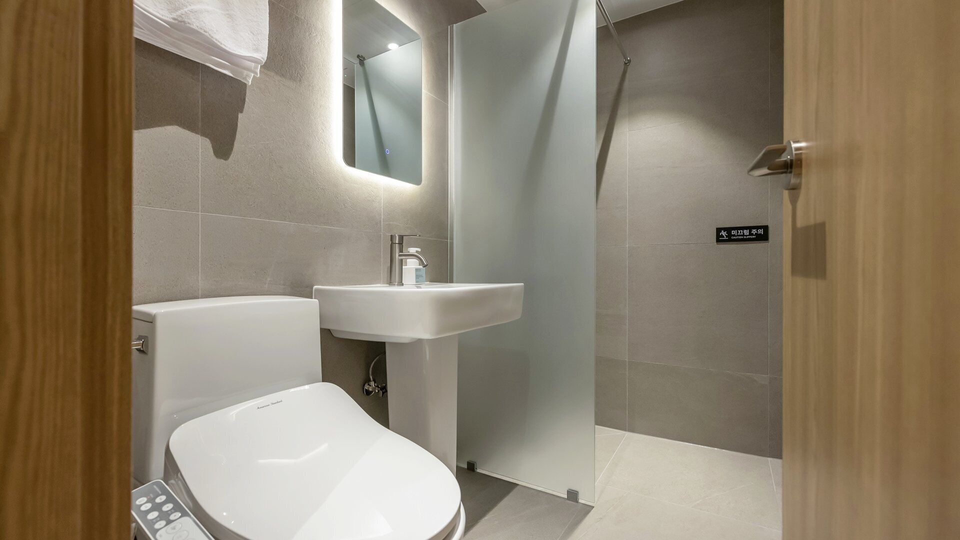 Un baño moderno con inodoro, lavabo y ducha.