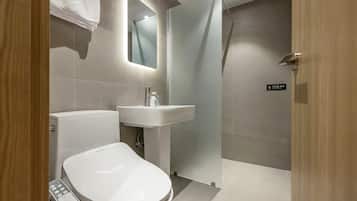 Un baño moderno con inodoro, lavabo y ducha.