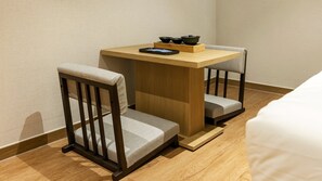 Una habitación pequeña y acogedora con una mesa de madera y dos sillas.