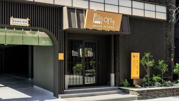 Un edificio con un letrero que indica un estacionamiento y el nombre 'ANOOK RYOKAN'.