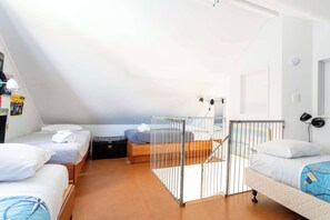 A compact, well-lit room with a sloped ceiling, a small staircase, and a bed with a metal railing. - The Lighthouse at Ligar Bay - Romantic Coastal Escape with Spa (Ligar Bay)