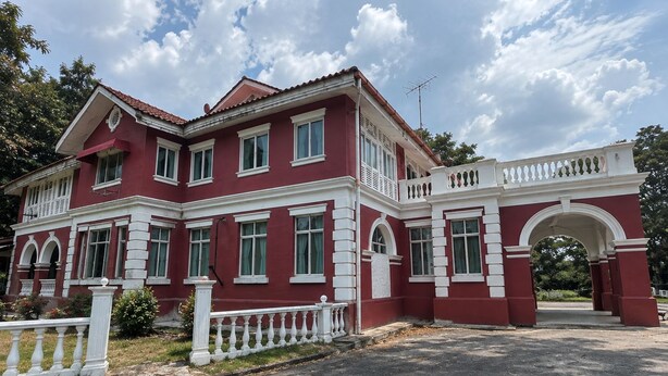 A two-story building with a symmetrical facade, multiple windows, and a central entrance with an archway. - Hotel & Recreation Apsara Bukit Residen (Kuala Lipis)