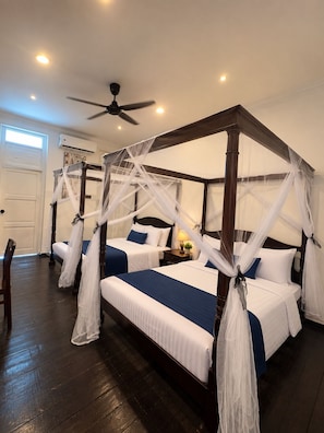A four-poster bed with white and blue bedding, a ceiling fan, and a nightstand with a lamp and a plant. - Hotel & Recreation Apsara Bukit Residen (Kuala Lipis)