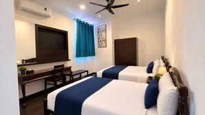 A hotel room with two beds, a desk, a chair, an air conditioning unit, a ceiling fan, and a window with curtains. - Hotel & Recreation Apsara Bukit Residen (Kuala Lipis)