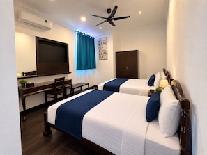 A hotel room with two beds, a desk, a chair, an air conditioning unit, a ceiling fan, and a window with curtains. - Hotel & Recreation Apsara Bukit Residen (Kuala Lipis)