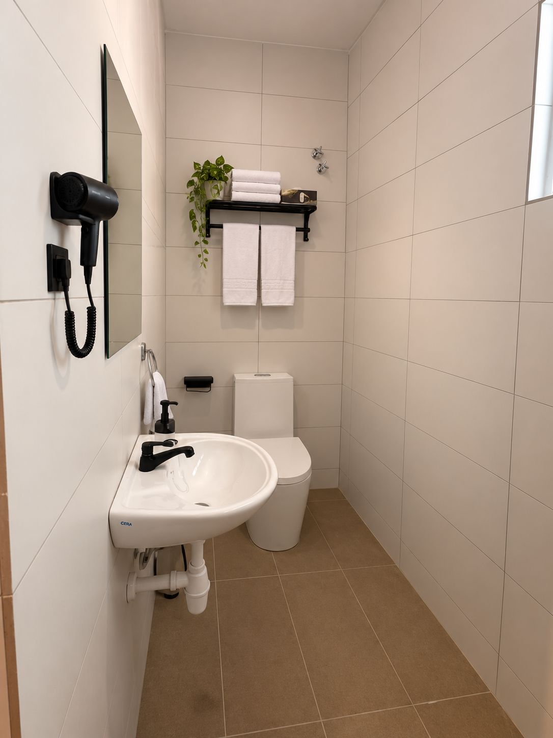 A modern bathroom with a white sink, toilet, and a hairdryer mounted on the wall.