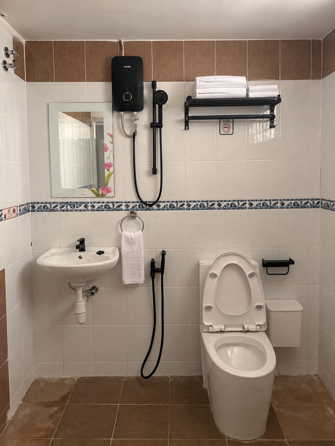A bathroom with a toilet, sink, and shower unit.
