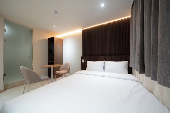 A modern hotel room with a large bed, a desk, and a chair. - Hotel Eden at Kyunghee Univ (Seoul)