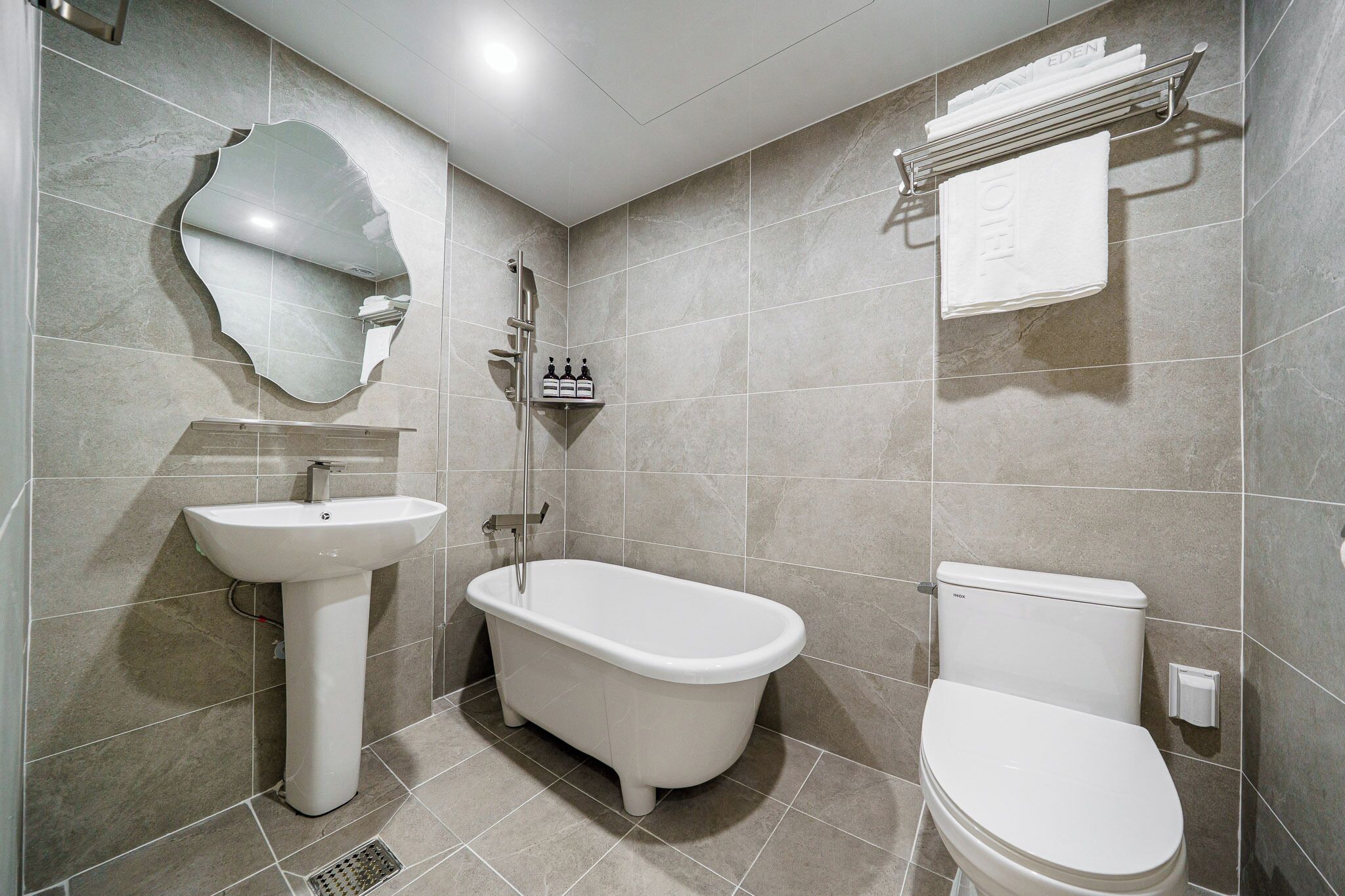 Un baño con lavamanos, bañera y retrete.