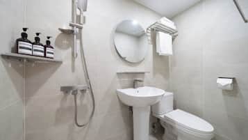 A modern bathroom with a shower, sink, toilet, and a towel rack.