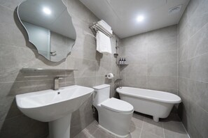 Un baño moderno con lavamanos, inodoro y bañera.