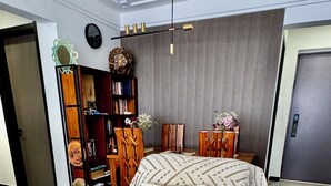 A modern living room with a sofa, a decorative wall, a bookshelf, and a door. - Zen On14, cozy 2bedroom in Lavington (Nairobi)