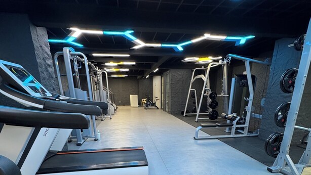 A gym with treadmills, weight machines, and a wall-mounted squat rack. - Zen On14, cozy 2bedroom in Lavington (Nairobi)