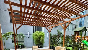 A wooden deck with outdoor seating and a pergola structure. - Zen On14, cozy 2bedroom in Lavington (Nairobi)