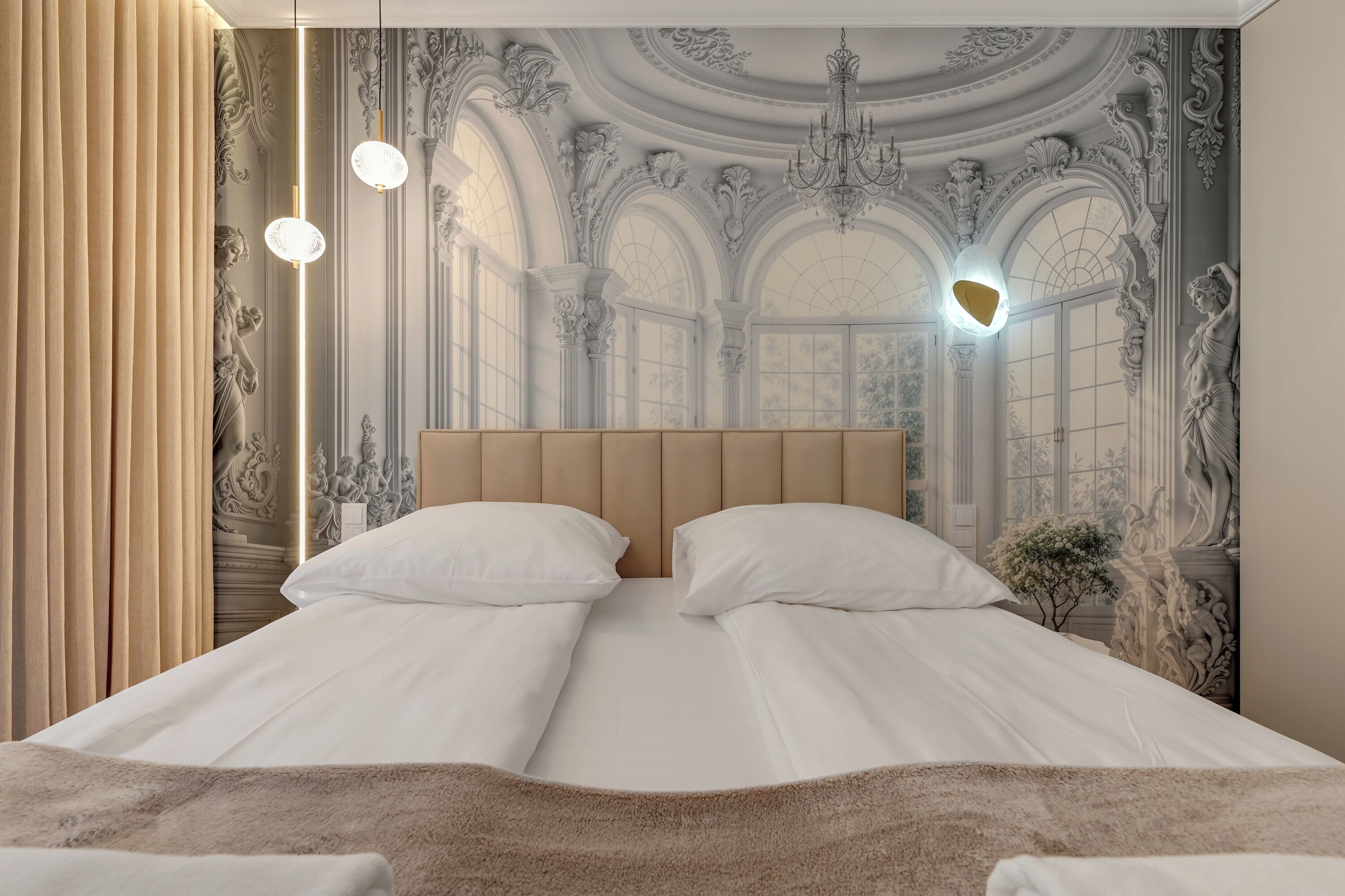 A bedroom with a large bed, two bedside lamps, and a decorative wall mural.
