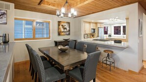 A dining area with a wooden table, six chairs, and a chandelier. - Old Town 3BR | Steps to Town Lift & Main St (Park City)