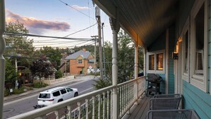 A porch with a railing, a grill, and a view of a street with a white van. - Old Town 3BR | Steps to Town Lift & Main St (Park City)