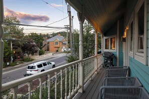 A porch with a railing, a grill, and a view of a street with a white van. - Old Town 3BR | Steps to Town Lift & Main St (Park City)