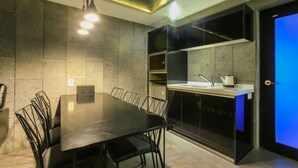 Una cocina moderna con comedor, equipada con una mesa grande y sillas, horno empotrado y pileta.
