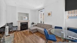 Una sala de estar moderna con un sofá modular, una mesa de centro de vidrio y una chimenea.
