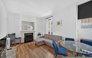 Ein modernes Wohnzimmer mit einem Ecksofa, einem Glastisch und einem Kamin.