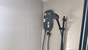 Eine Dusche mit Handbrause und einer fest installierten Bedienkonsole.