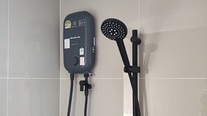 Eine Duschkabine mit Handbrause und fest installierter Bedienung.