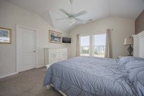 A bedroom with a bed, a ceiling fan, a dresser, a television, and a window with blinds. - 5433 - Sonnie Beaches Ocean-view 4BR, 4.5BA home with private pool, hot tub, and game room. (Nags Head)