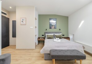 A modern bedroom with a bed, bedside tables, a bench, and a wall-mounted artwork. - Szczecin Classy City Studio (Szczecin)