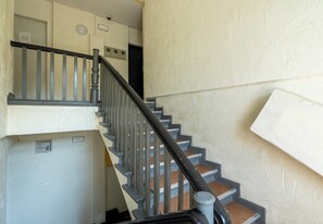 A staircase with a handrail and a wall-mounted intercom. - Szczecin Classy City Studio (Szczecin)