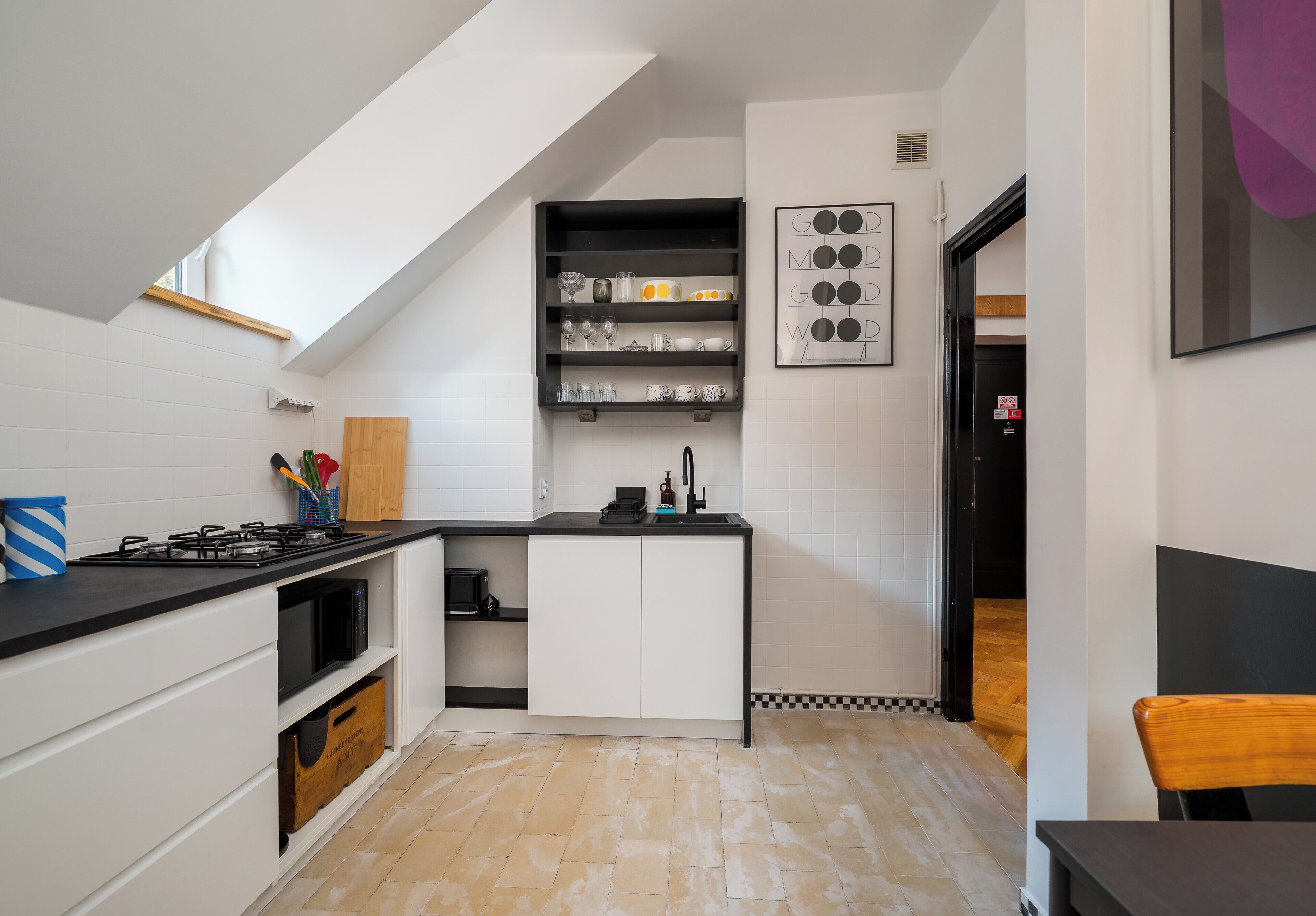 A compact kitchen with a gas stove, microwave, and a small island with a sink.