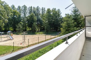 Ein Spielplatz mit Klettergerüsten und Sandkasten, umgeben von Bäumen.
