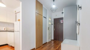 Una cocina moderna con armarios blancos, una puerta de madera y una encimera blanca.