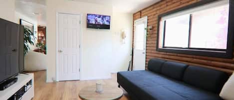 A modern living room with a sofa, a television, and a small table.
