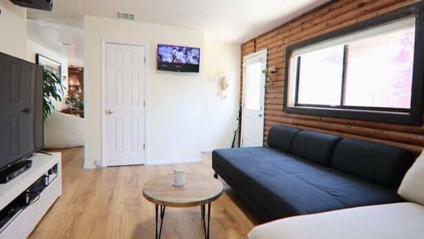 Ein modernes Wohnzimmer mit einer Couch, einem Fernseher und einem kleinen Tisch.