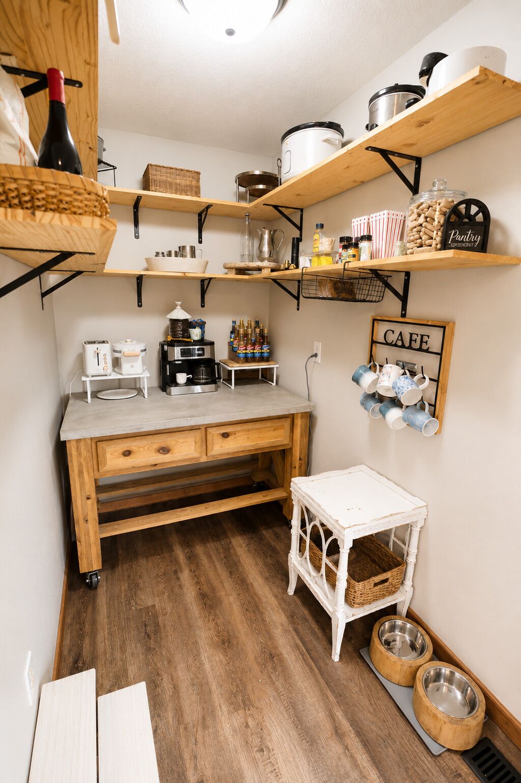 Une cuisine compacte avec des étagères en bois, un coin café et un espace dédié à l’alimentation des animaux de compagnie.