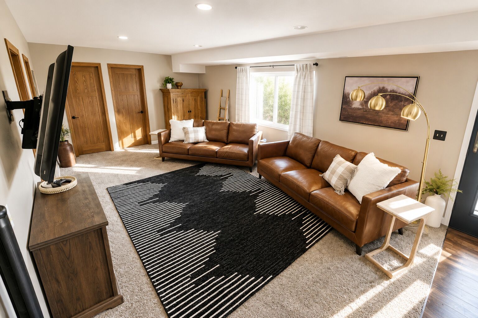 A modern living room with a brown leather sofa, a black and white striped rug, and a wooden cabinet.