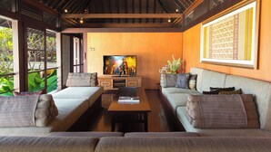 Ein modernes Wohnzimmer mit Fernseher, Sofas und einem Couchtisch.