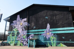 Un edificio con un mural de flores púrpuras y diseños geométricos.