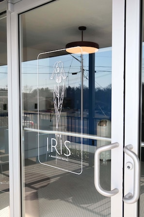 A glass door with a logo and text indicating 'The Iris Boutique Motel.' - The Iris Motel - Queen Room (Nashville)