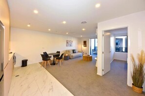 Ein modernes Wohnzimmer mit Sofa, Couchtisch und Essbereich.