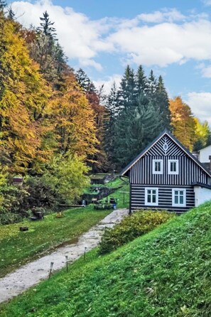 A traditional black and white house with a symmetrical facade, a central chimney, and a small porch area. - Vacation home Sára by Interhome (Janské Lázně)