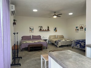 A room with two beds, a ceiling fan, recessed lighting, and wall art. - Casa Valencia. Two Studios residence. Fully equipped for comfort and connection. (Barra de Navidad)