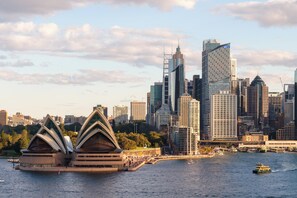 A city skyline with modern buildings and the Sydney Opera House. - Stunning Harbour View Modern Retreat in Kirribilli with aircon and free parking (Kirribilli)