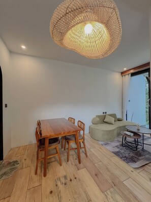 Un interior moderno con una mesa de comedor, sillas, un sofá y una lámpara colgante.