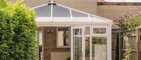 Una casa con un porche techado, una ventana visible y un jardín.