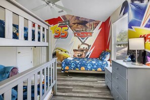 A child's bedroom with a mural of 'Cars' characters, bunk beds, a desk, and a window with blinds. - Casa de sueños -king of kings (Clermont)