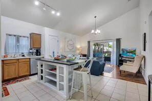 A modern kitchen with a dining area, a TV, and a balcony with outdoor seating. - Casa de sueños -king of kings (Clermont)