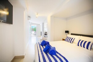 Habitación de hotel con una cama, un televisor de pantalla plana en la pared y vistas al área exterior.