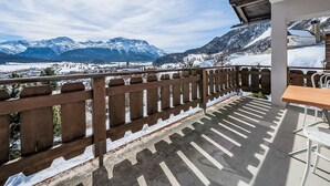 Ein Balkon mit Blick auf schneebedeckte Berge und einen klaren Himmel.